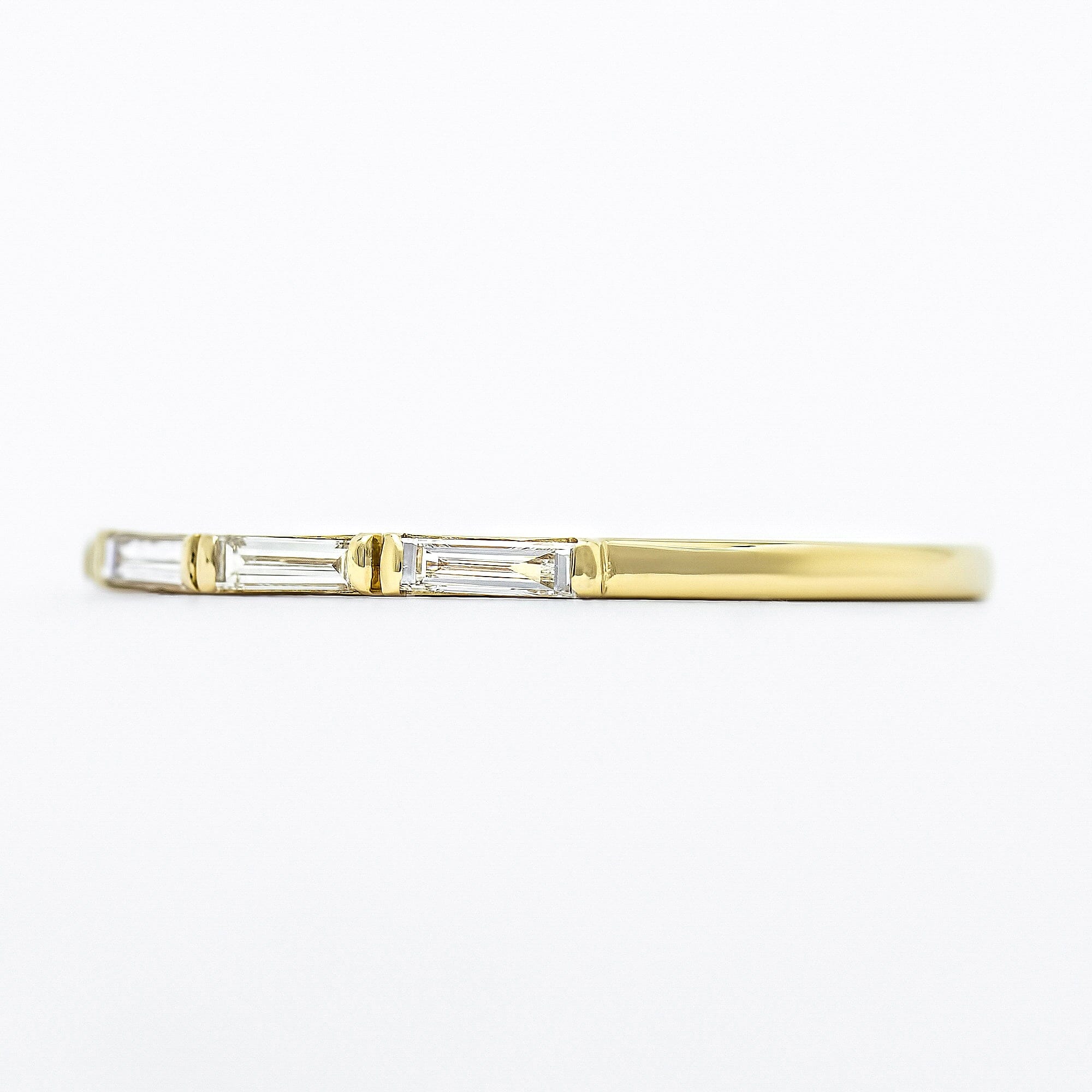 A side profile view of the diamond baguette wedding band
